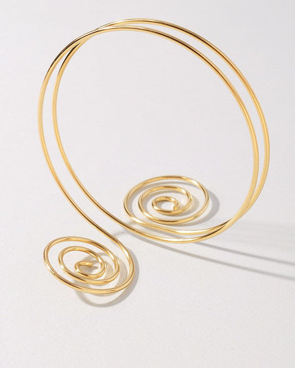 Curved gold-tone metal bicep cuff with coiled spiral detailing

