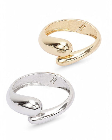 Chunky gold bracelet with fluid shape and glossy reflective surface

