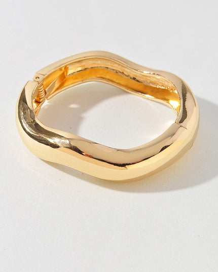 Gold sculptural bracelet with square rounded edges and glossy finish

