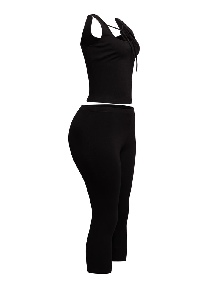 Chic black two-piece set featuring a tie-front crop tank and capri pants, perfect for a bold and versatile look.