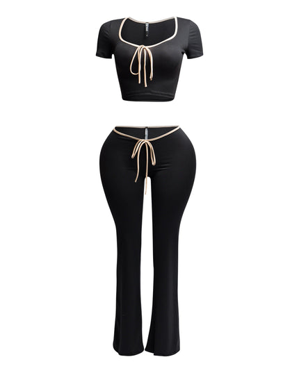 Front view of black two-piece set with nude trim, featuring a scoop-neck crop top and high-waisted flared pants.
