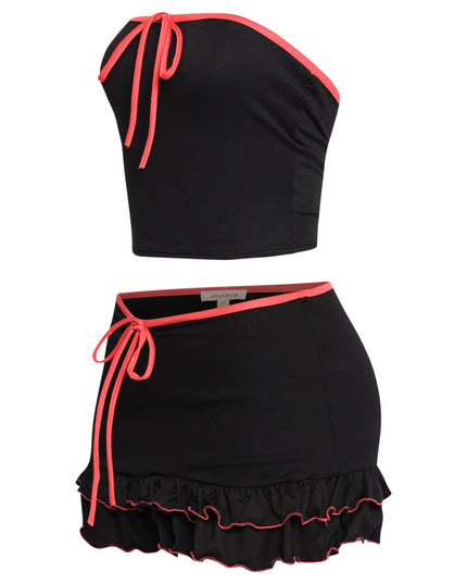 Trendy two-piece black outfit with vibrant pink accents, relaxed fit, and layered ruffle mini skirt