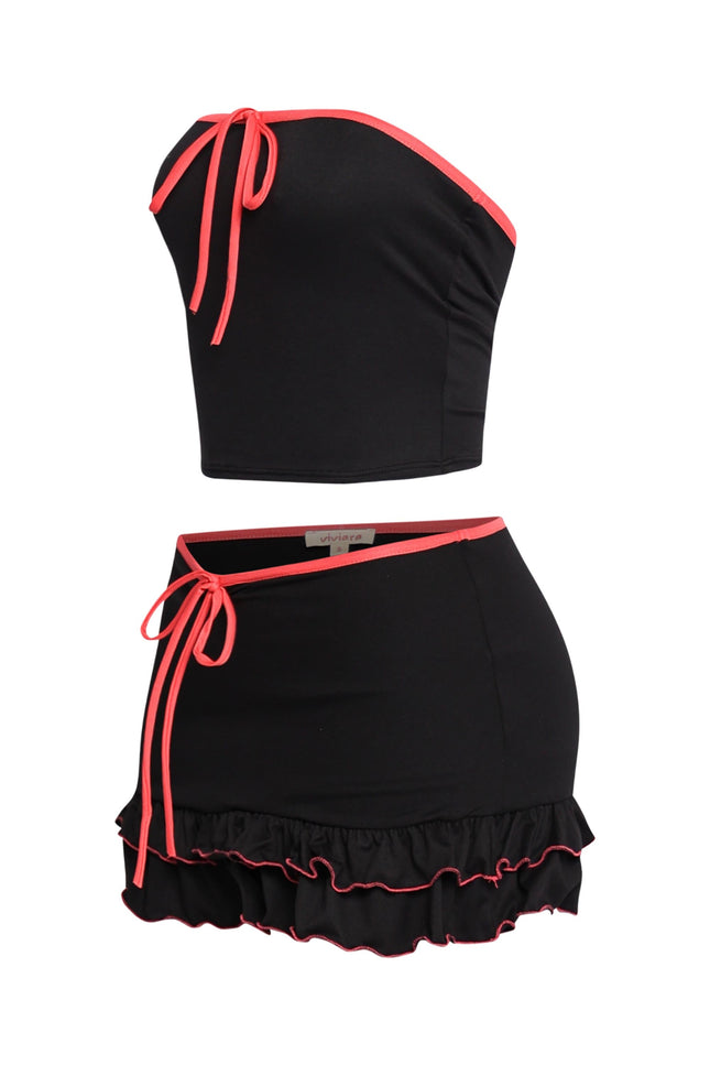 Trendy two-piece black outfit with vibrant pink accents, relaxed fit, and layered ruffle mini skirt