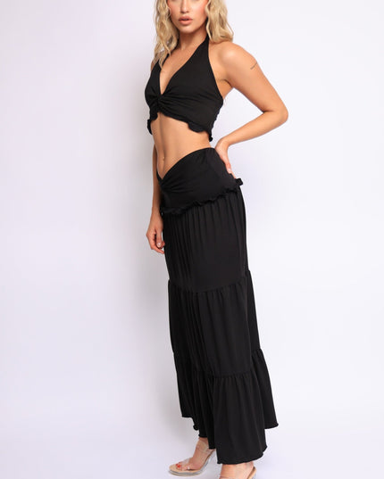 Black halter neck twist-front crop top paired with tiered low-rise maxi skirt

