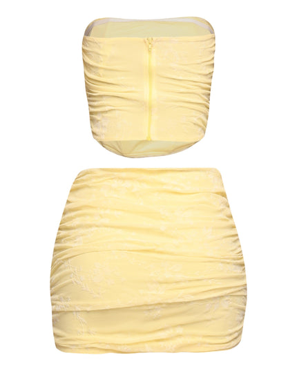 Side view of yellow ruched jacquard tube top and curve-hugging mini skirt

